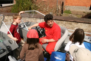 Der 1. Vorsitzende des DLRG Bezirksverbandes beantwortet interessierten Kindern Fragen über das Boot